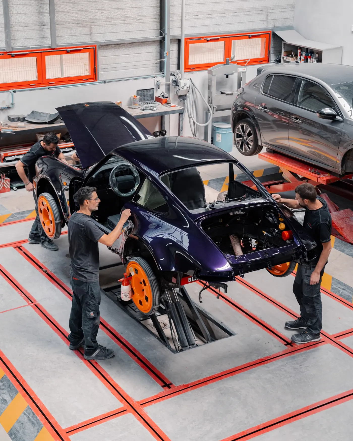 Porsche 911 en cours de remontage dans un atelier de carrosserie