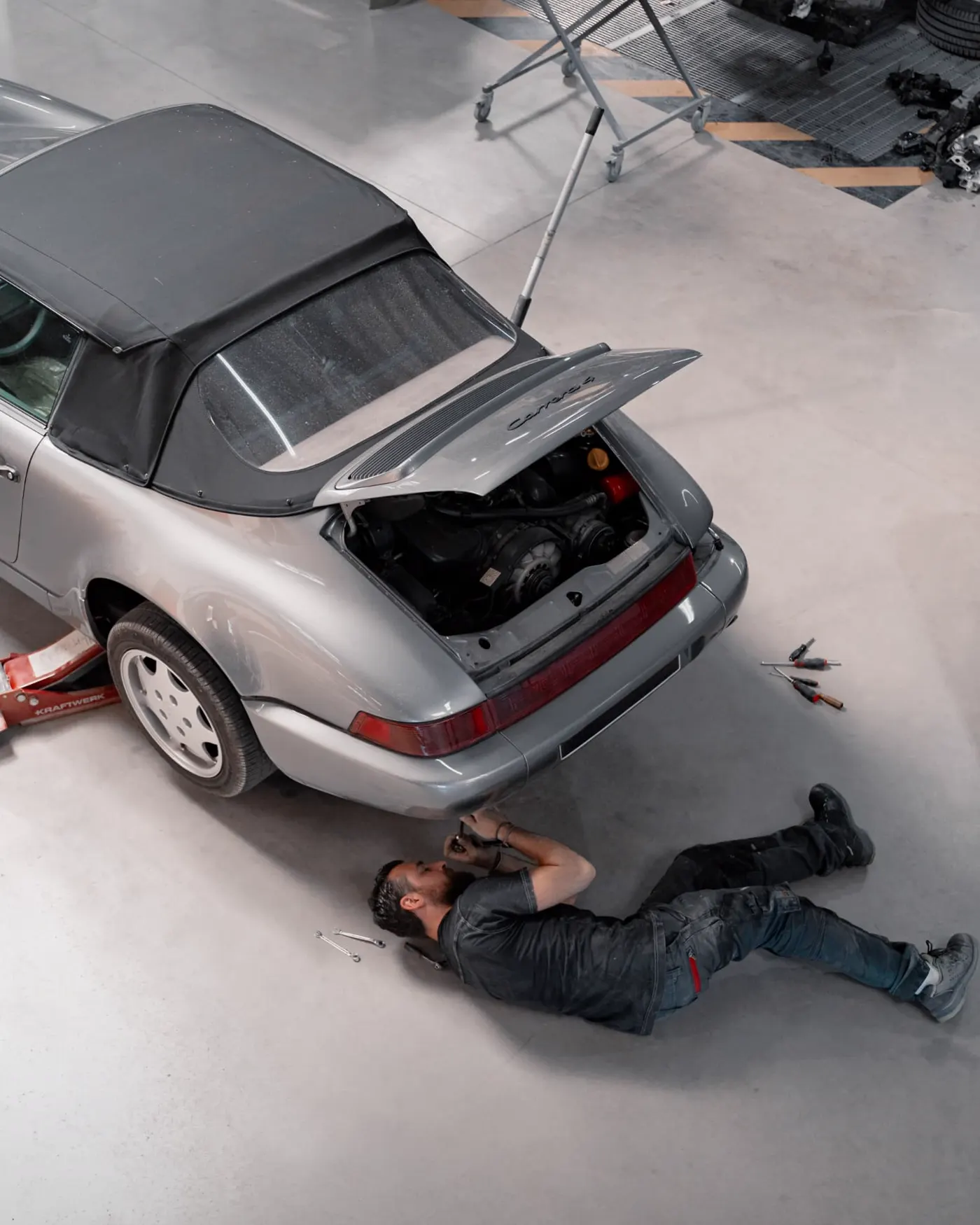 Intervention sous une Porsche 911 cabriolet grise