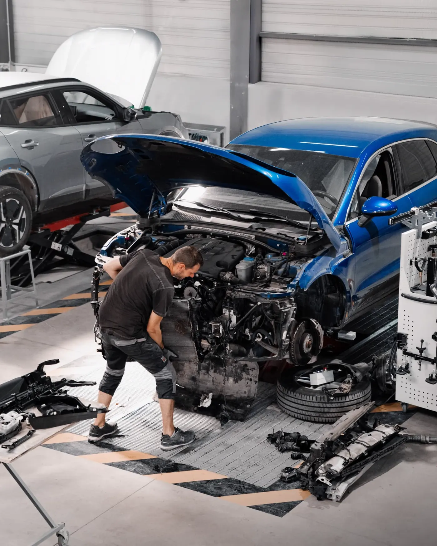 Depose d'un bloc avant sur un vehicule bleu en atelier