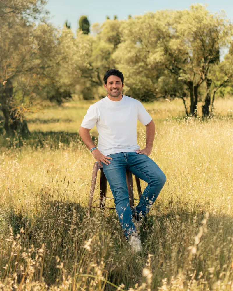 Mathieu Delranc, fondateur de BICPOM, assis sur un tabouret dans une oliveraie en Provence